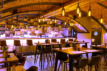 Interior of cozy modern restaurant with a bar counter and lamp lighting