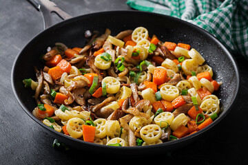 Rotelle pasta gluten free with mushrooms and pumpkin on a dark background. Vegetarian, vegan  food. Italian cuisine.