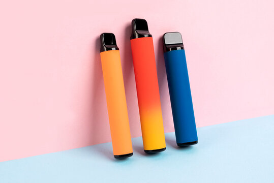 Set Of Colorful Disposable Electronic Cigarettes On A Pink Background. The Concept Of Modern Smoking, Vaping And Nicotine.