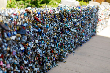 Fototapeta premium Old and new padlocks with names and dates written on them lock on a bridge as a sign of love in San Antonio, Texas.
