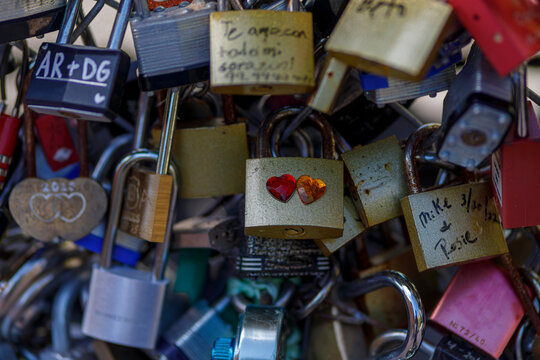 Old and new padlocks with names and dates written on them lock on a bridge as a sign of love in San Antonio, Texas.