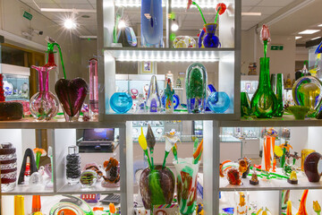 Variety of glass souvenirs figurines on the shelves of the store