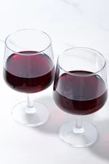Fotobehang 赤ワインが入ったワイングラスで乾杯 © theghan