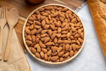 Roasted Almond on wooden table, Almond in wooden plate ready to serve.