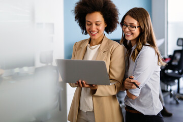 Happy smiling business women working together online on a laptop in office