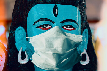 Indian god Shiva in a medical mask to protect against coronavirus. Concept - Hindu temples are...