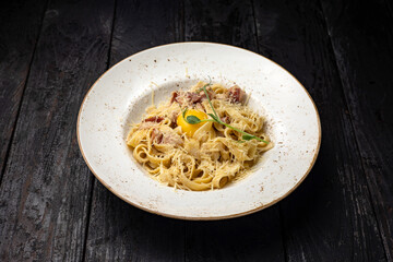 delicious pasta with cheese, egg, greens, sauce in a restaurant
