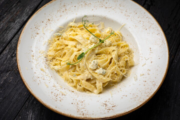 delicious pasta with cheese, greens, sauce in a restaurant
