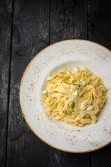 delicious pasta with cheese, greens, sauce in a restaurant
