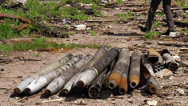 demining works
Unexploded ammunition of various calibers are stacked on the floor
someone is walking in the background