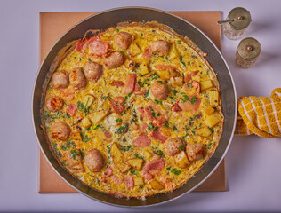 Italian styled bacon,sausage and potato frittata resting in a pan.