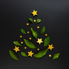 Fototapeta na wymiar Christmas tree, made of green leaves and golden stars, minimal concept of new year. 