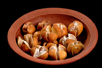 lime pickles in a clay pot, lime preserving process with salt, closeup, Sri Lankan home made lime pickle, isolated on black (Lunu Dehi)
