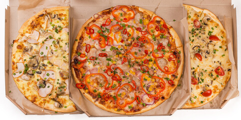 Three cooked round pizza with different stuffing in pizza boxes
