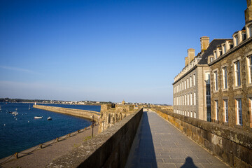Saint-Malo lighthouse and pier view from the city fortifications, Brittany, France - obrazy, fototapety, plakaty