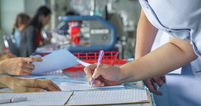 Nurse Or Medical Staff Applicant Filling In Company Application Form Document Applying For A Job, Or Registering Education Training.