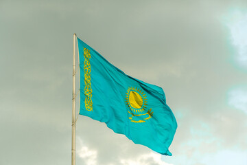Flag of Kazakhstan on sky background. Waving flag of Republic of Kazakhstan. Fabric textures flowing flag of Kazakhstan.