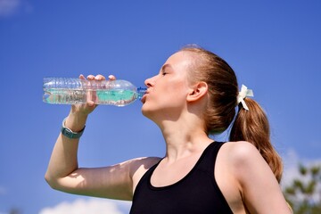 profile photo of young thirsty woman, beautiful athletic girl jogger is drinking pure fresh water...