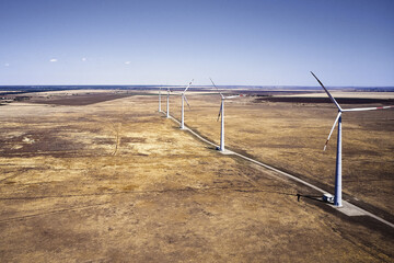 Fototapeta premium wind power plant in the steppe against the blue sky shooting from a drone