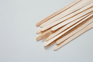 Materials for depilation of eyebrows and delicate areas. Wooden sticks lie on a white background