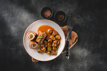Pork roulade with pickles and bacon, served with fried mushrooms and green onions