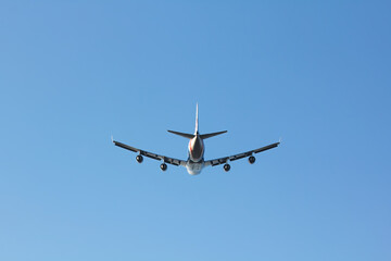747 tail view wheels up in a blue sky - stock photo.jpg