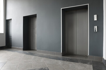 Closed stylish elevator doors in clean hall