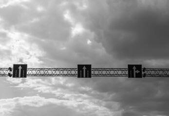 road signs over the highway in black and white