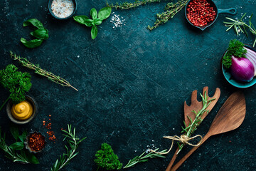 Kitchen utensils, spices and herbs on a stone background. Cooking concept. Top view. Free space for your text.