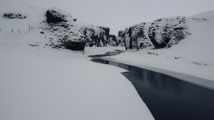 Lost snowy river in iceland, a frozen stone canyon.