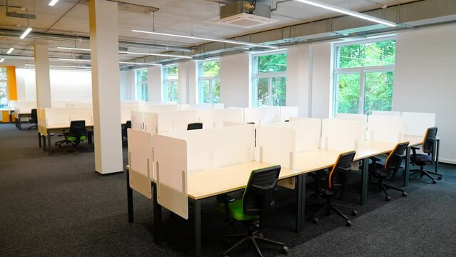 Static background, the interior of an office space and empty workspaces, natural lighting, background template for chromakey.