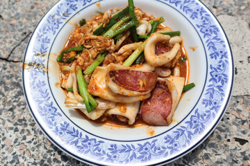 Stir-fried squid with roasted chili paste (Pla meuk pad nam prik paw). Stir-fry squid in Thai style. Popular Thai food recipe. 