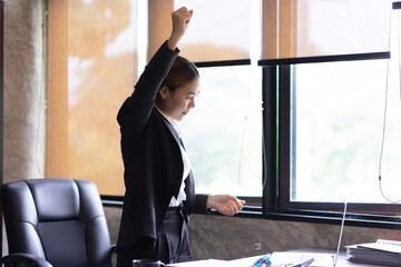 Portrait of female office worker celebrating on her accomplishment while standing at the office...