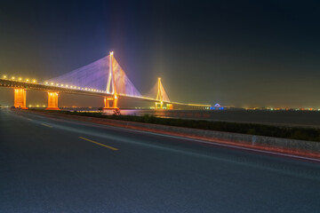 Fototapeta na wymiar Suzhou Yangtze River Bridge, asphalt road and night view of the Yangtze River in China