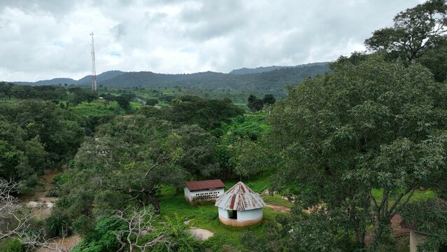 Aerial city view of a small house in green field Jos, Nigeria from high above