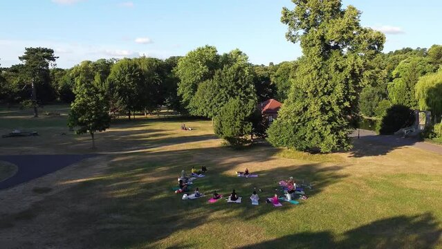 Editorial Use Footage. Group of English Women doing Yoga Exercise with a lady instructor at Local Public Park of Luton Town of England UK on a hot summer day at sunset time	
