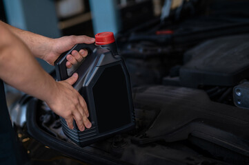 Auto mechanic performing the motor oil change