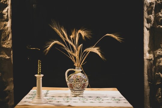 Vase full of golden wheat plants on the table
