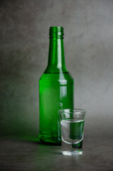 soju with glass on grey background, selective focus in vertical view