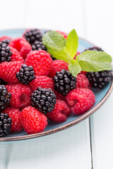 Fresh raspberries in a plate on a  vintage background.