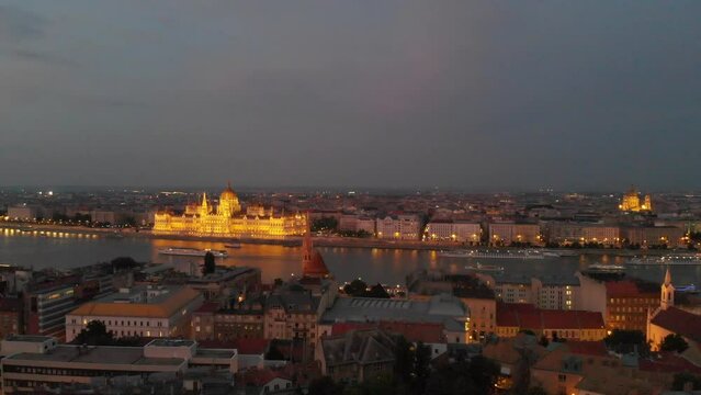 Steady aerial view of the illuminated Hungarian Parliament at the Danube River, located between Buda and Pest