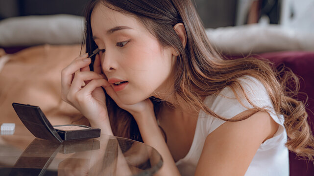 Young Asian Woman Putting Mascara Makeup In Mirror Banner Getting Ready For Work Doing Morning Makeup Routine Putting Mascara In Bathroom Mirror At Home.