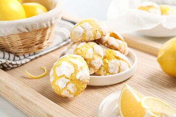 Tasty homemade lemon cookies and fresh fruits on wooden tray, closeup