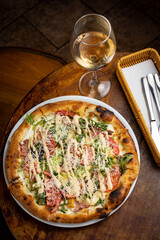 delicious pizza with cheese, greens, sauce in a restaurant
