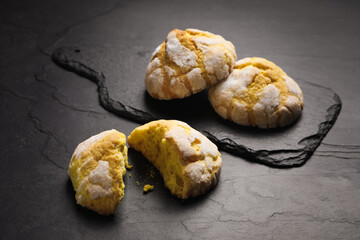 Fresh delicious lemon cookies on black table