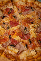 delicious pizza with cheese, greens, sauce in a restaurant
