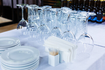 Set of clean dishes and glasses on table against white background