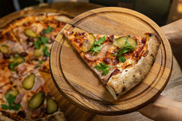 delicious pizza with cheese, greens, sauce in a restaurant
