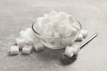 Bowl with sugar cubes served on grey table