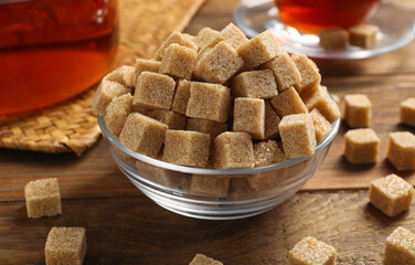 Brown sugar cubes on wooden table, closeup